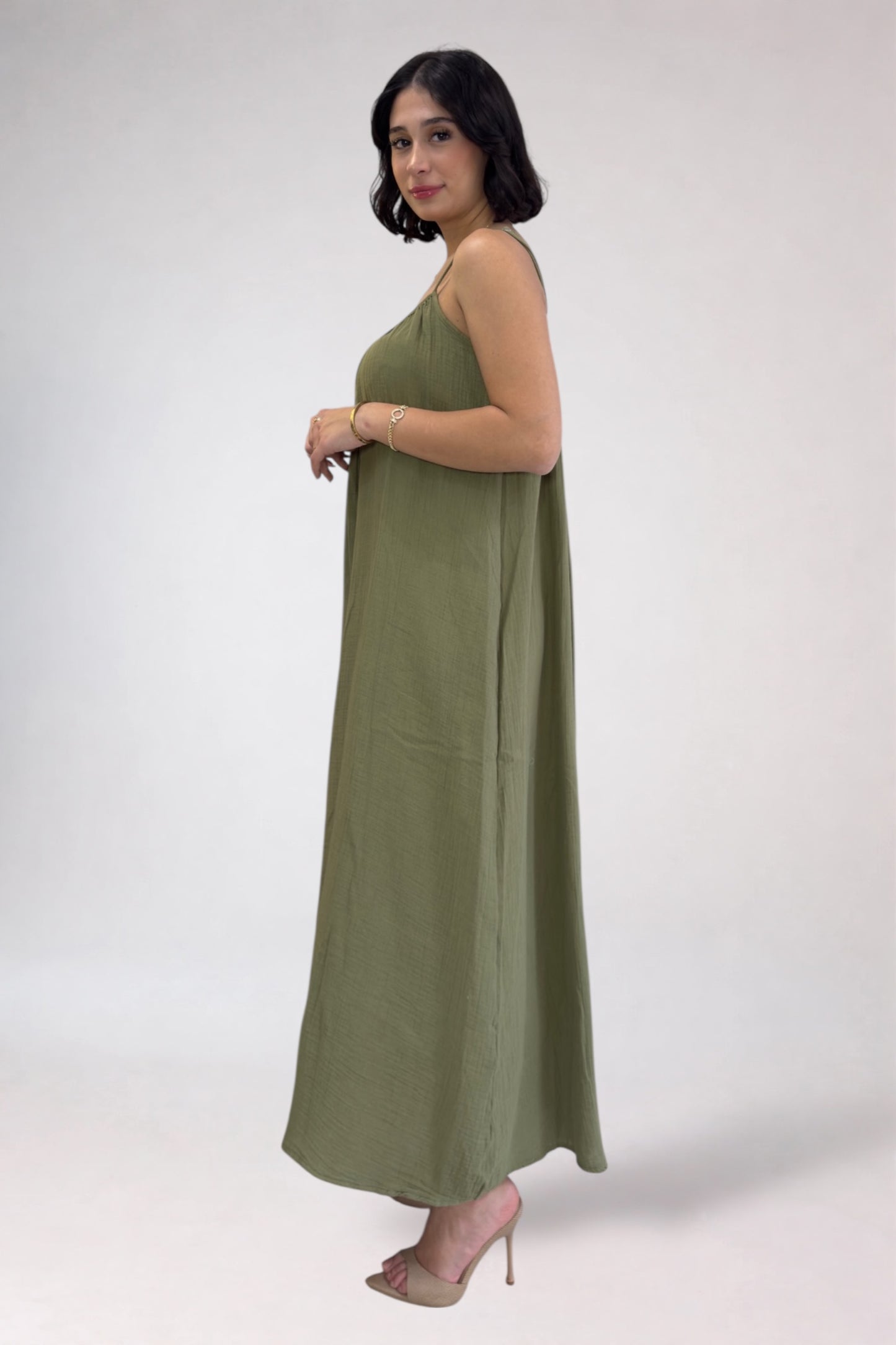 Woman wearing a long green dress on a white background