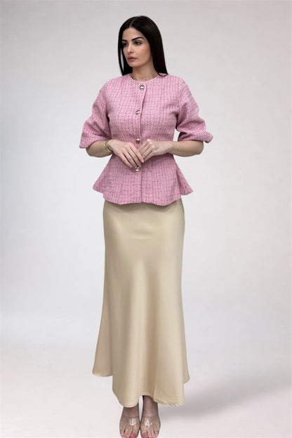 Woman wearing a pink checkered top and beige skirt on a white background