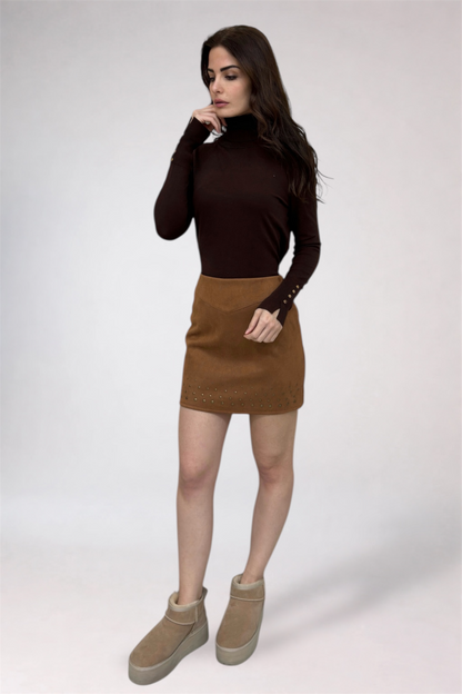 Woman wearing a brown turtleneck and tan skirt on a white background