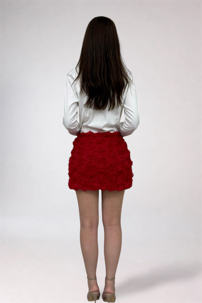 Person wearing a white blouse and red skirt on a plain background
