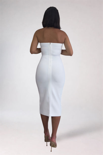 Woman wearing a white strapless dress on a plain background