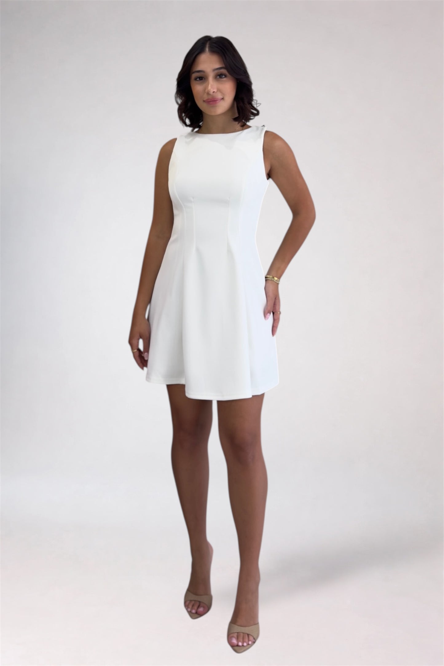 Woman wearing a white dress against a plain background