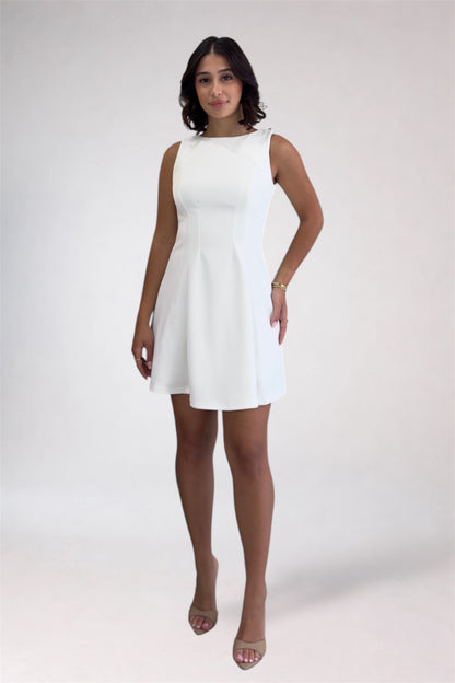 Woman wearing a white dress against a plain background