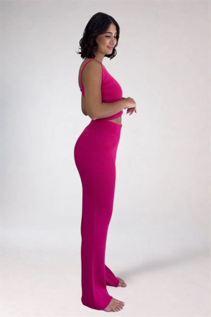 Woman wearing a bright pink outfit on a white background