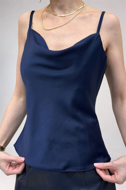 Navy blue spaghetti strap top worn by a person on a plain background