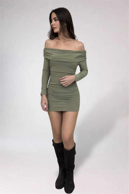 Woman wearing a green off-shoulder dress with long sleeves on a white background