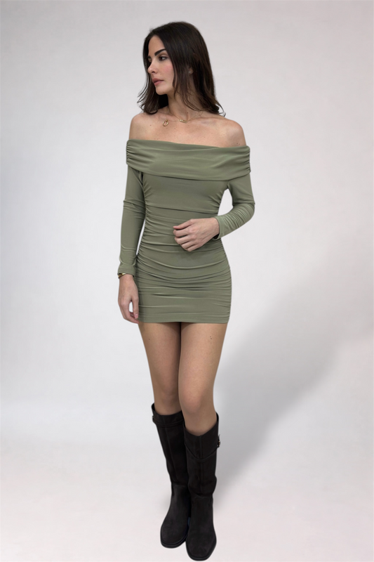 Woman wearing a green off-shoulder dress with long sleeves on a white background