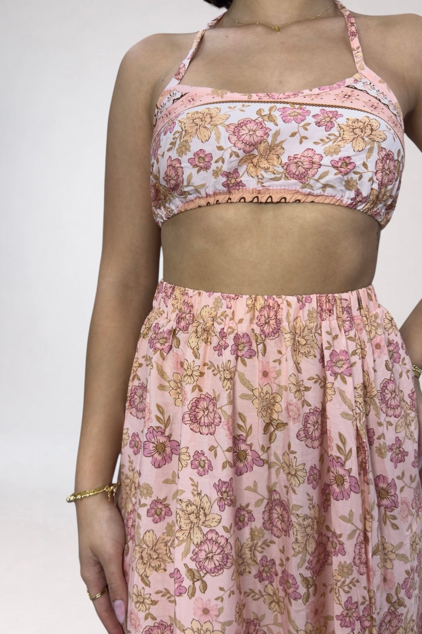 Person wearing a floral two-piece outfit with a white background