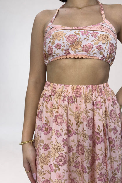 Person wearing a floral two-piece outfit with a white background