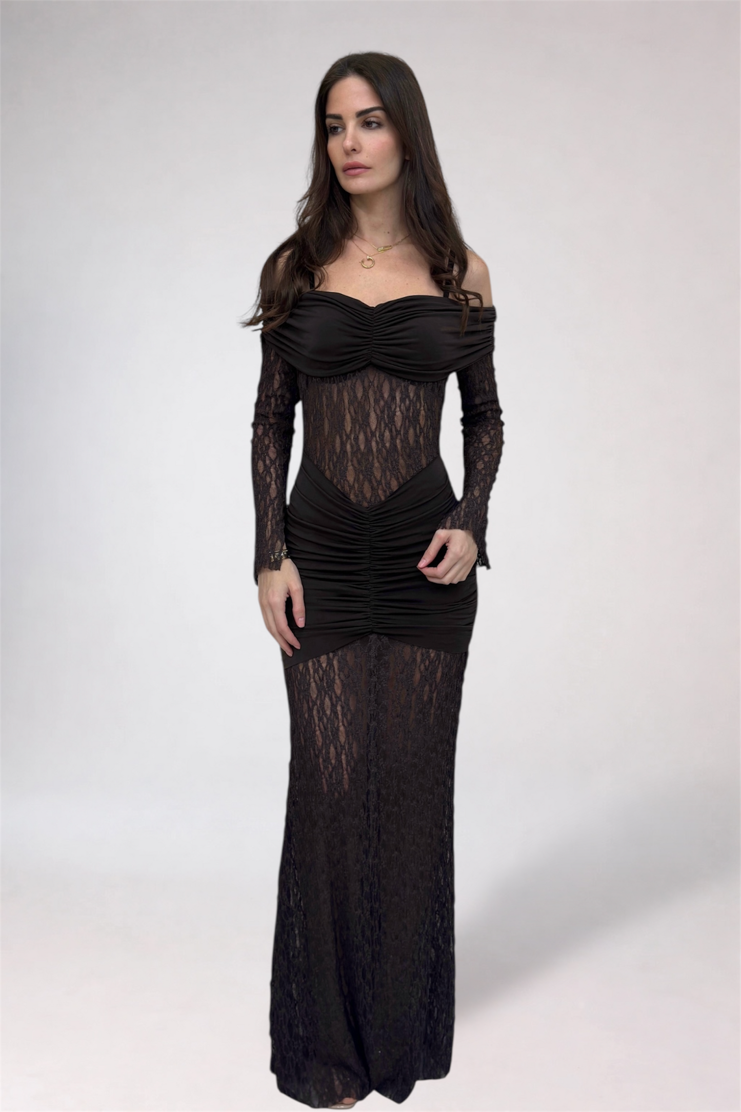 Woman wearing a black lace dress against a white background