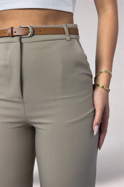 Beige pants with a brown belt and white background