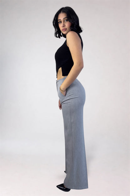 Woman wearing a black top and gray pants on a white background