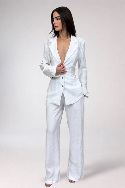 Woman wearing a white suit against a plain background