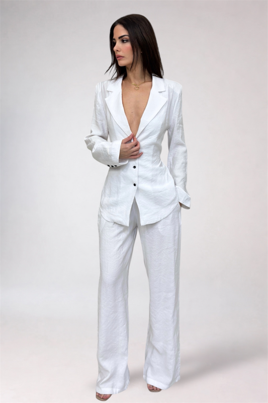 Woman wearing a white suit against a plain background