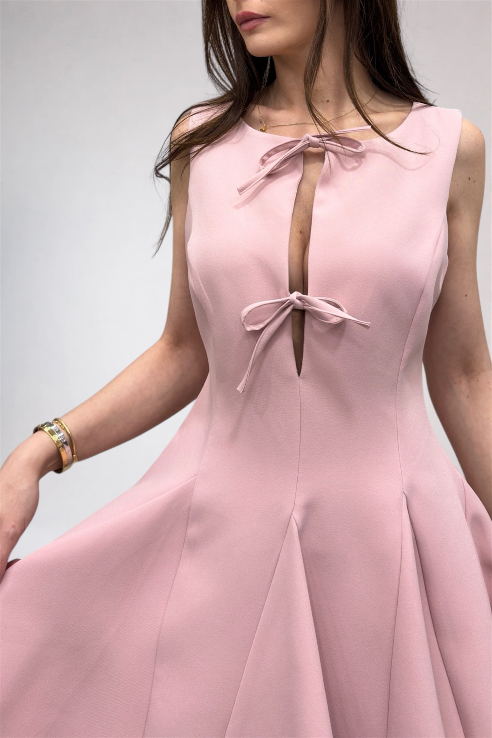 Pink dress with bow details on a plain background