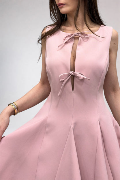Pink dress with bow details on a plain background