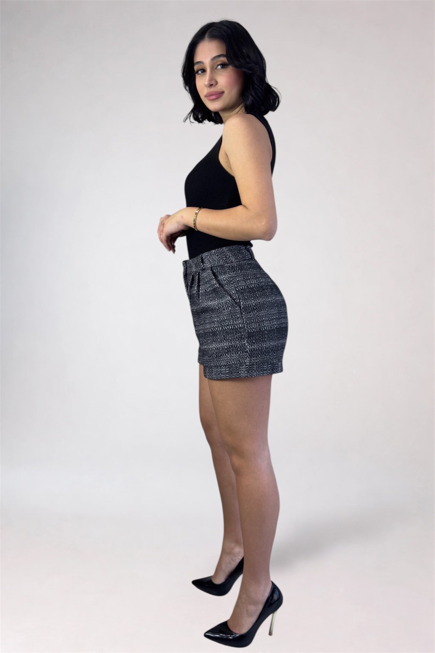 Woman wearing a black top and denim skirt on a white background