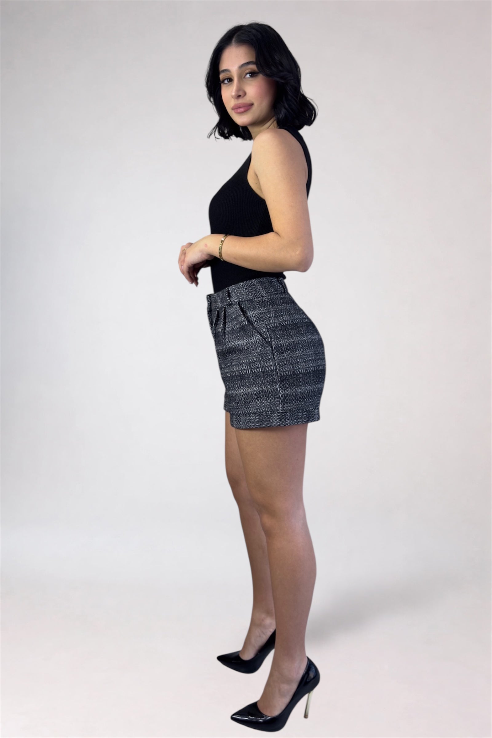 Woman wearing a black top and denim skirt on a white background