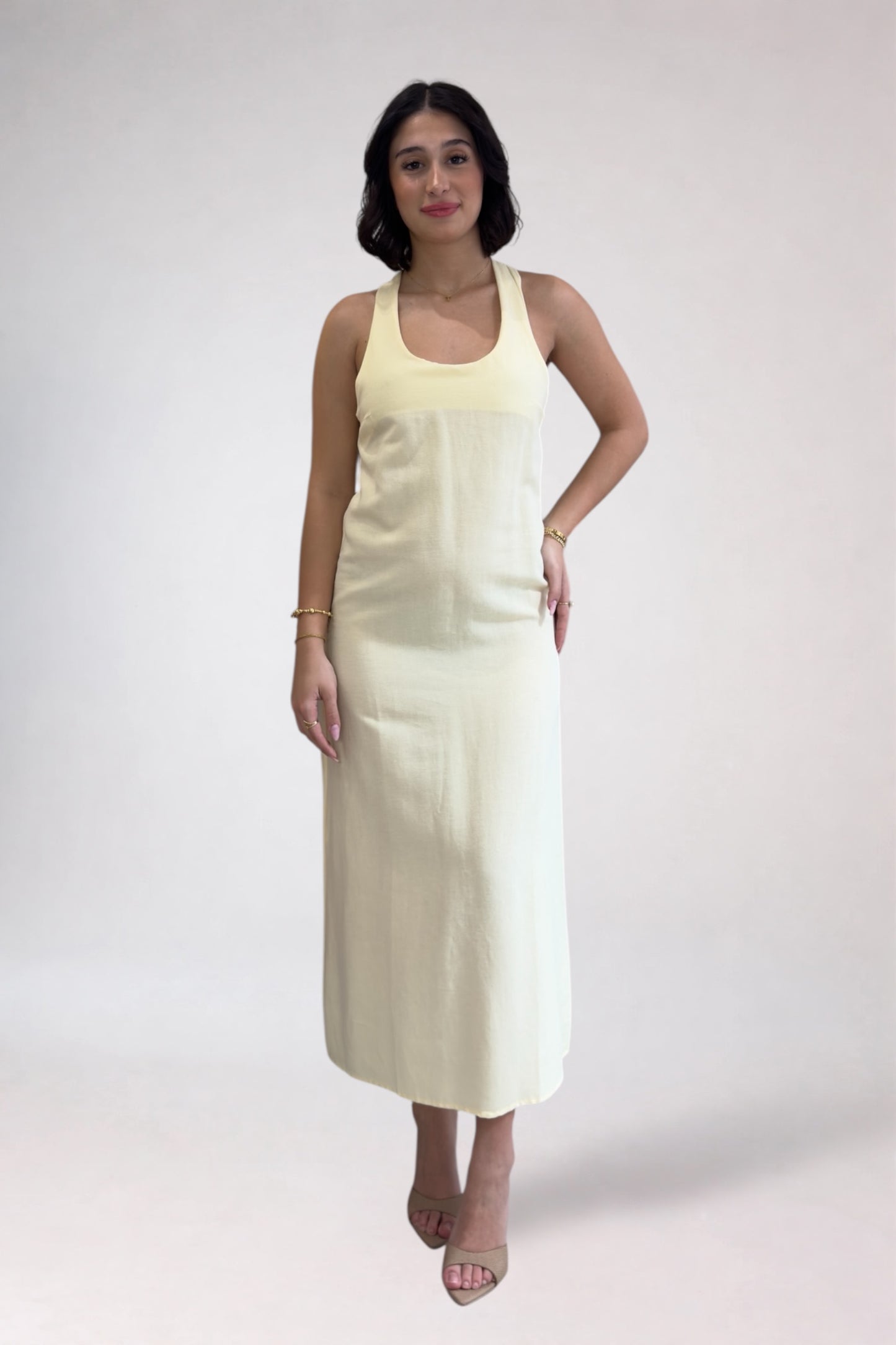 Woman wearing a light-colored dress against a white background