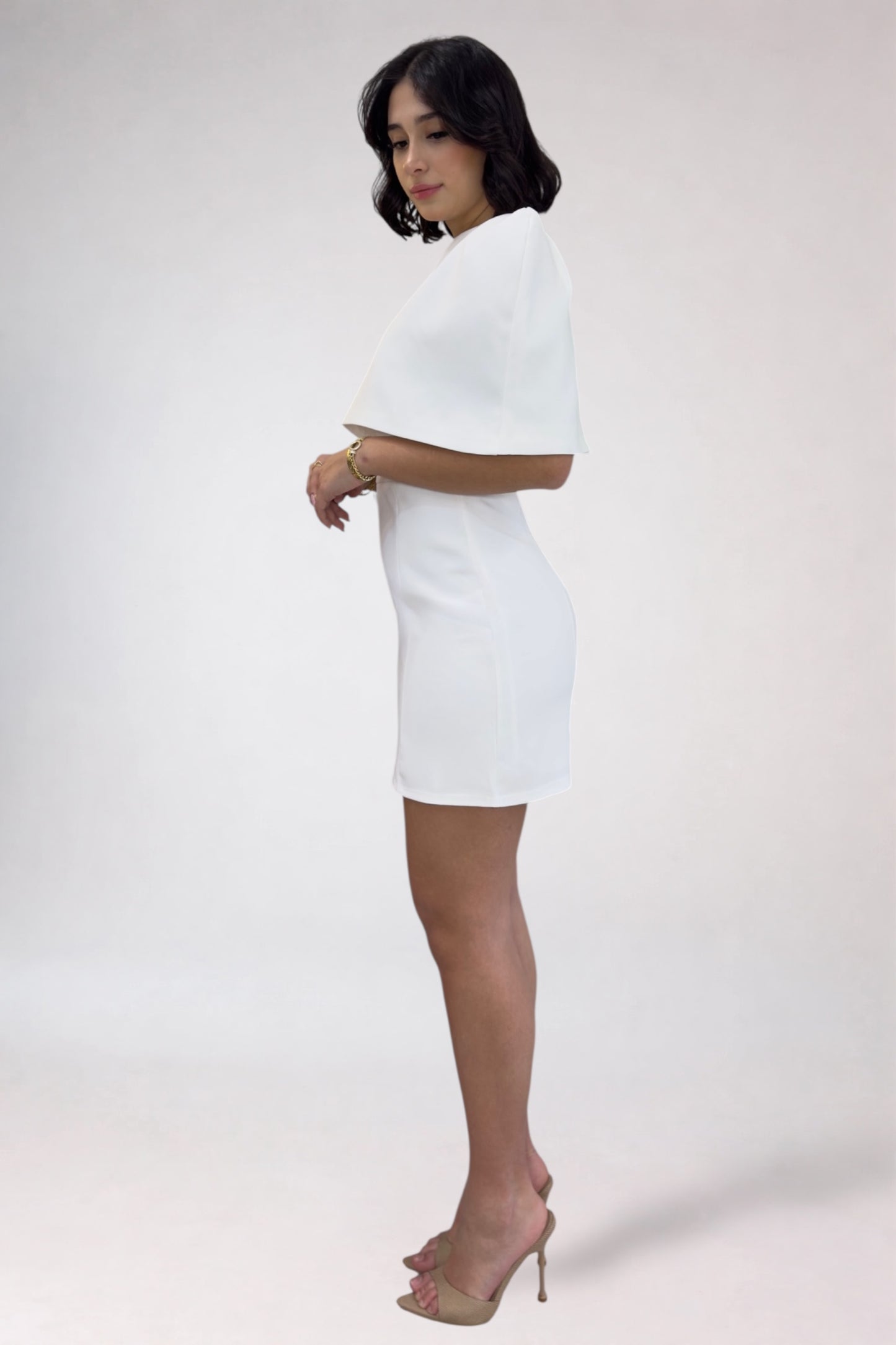 Woman wearing a white dress against a plain background
