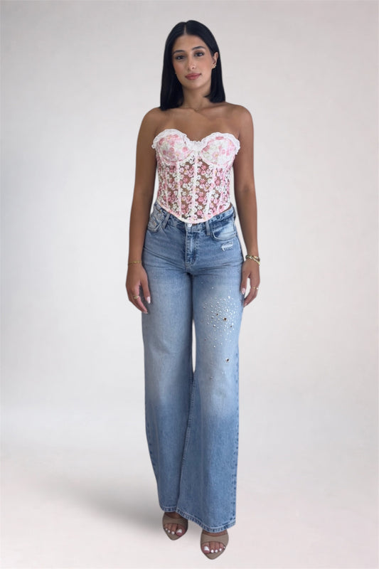 Woman wearing a lace top and blue jeans on a white background