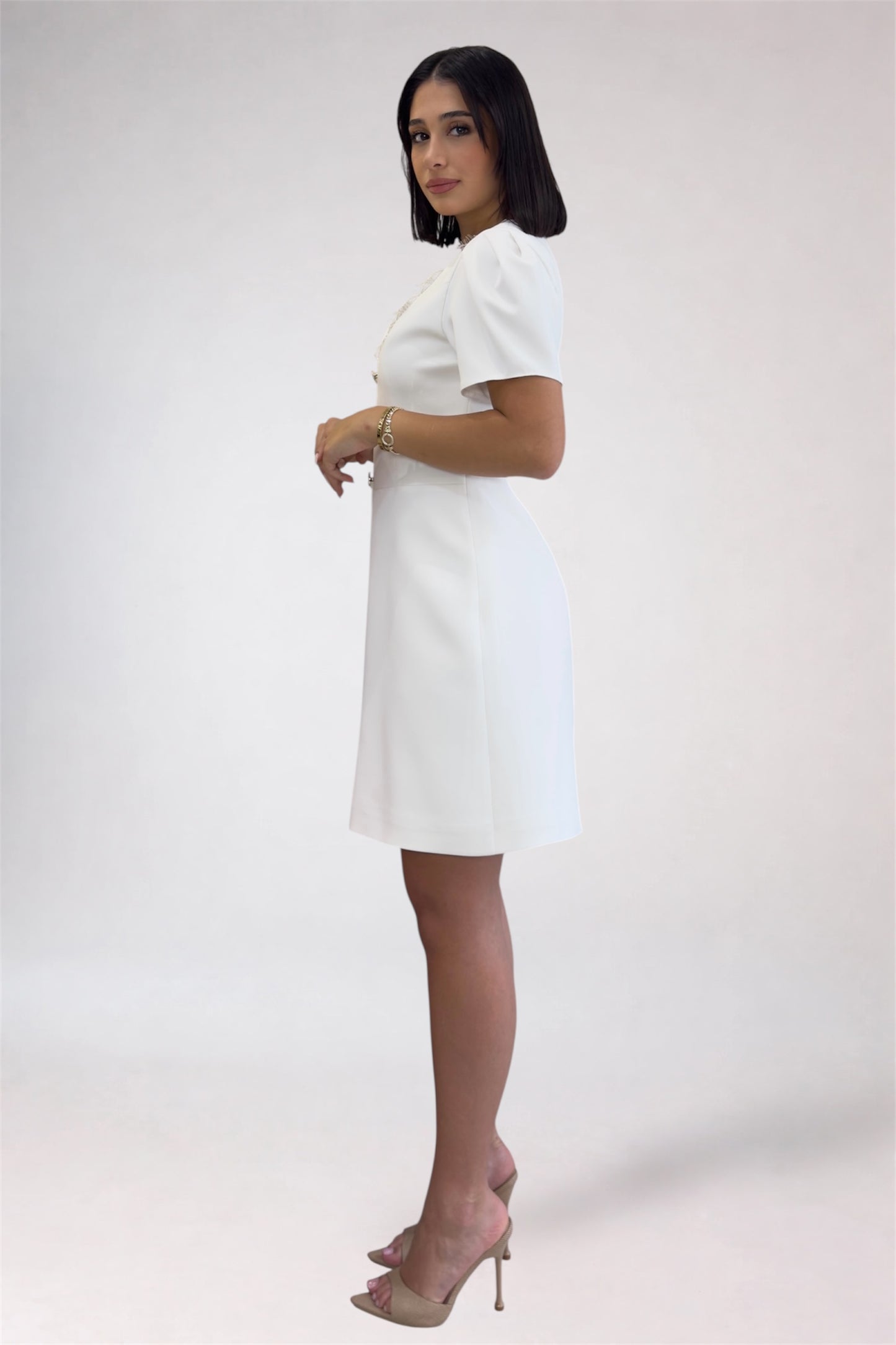 Woman wearing a white dress on a plain background