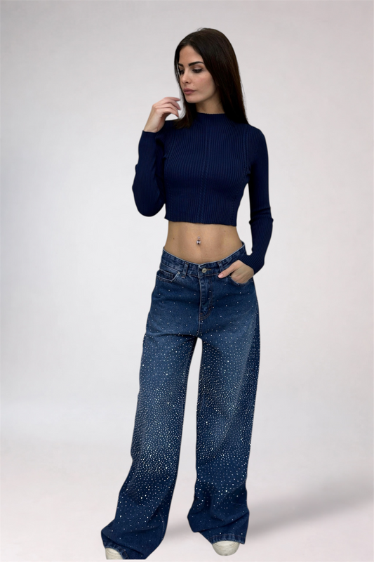Woman wearing a dark blue ribbed top and wide-leg jeans on a white background