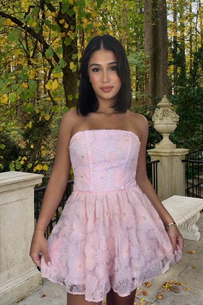 Woman wearing a light pink strapless dress in a garden setting