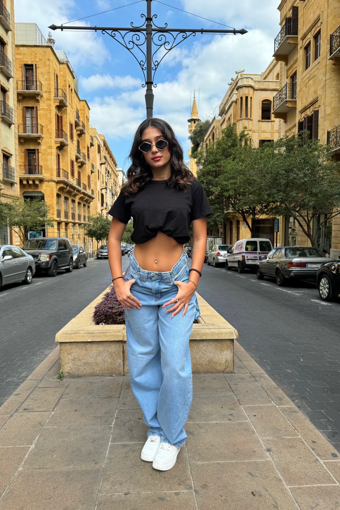 Woman standing on a street with buildings and cars in the background