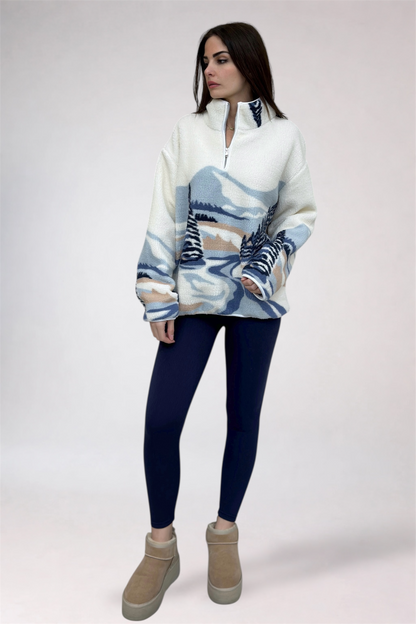 Woman wearing a patterned sweater and dark leggings on a white background