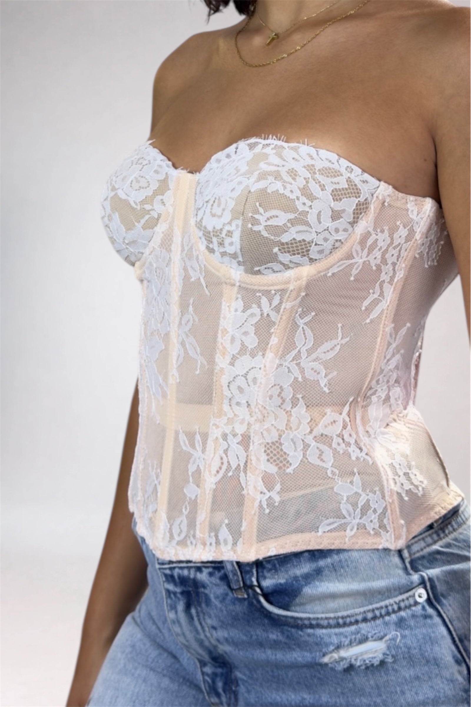 White lace top worn by a person on a plain background