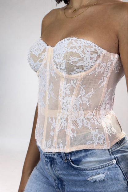 White lace top worn by a person on a plain background
