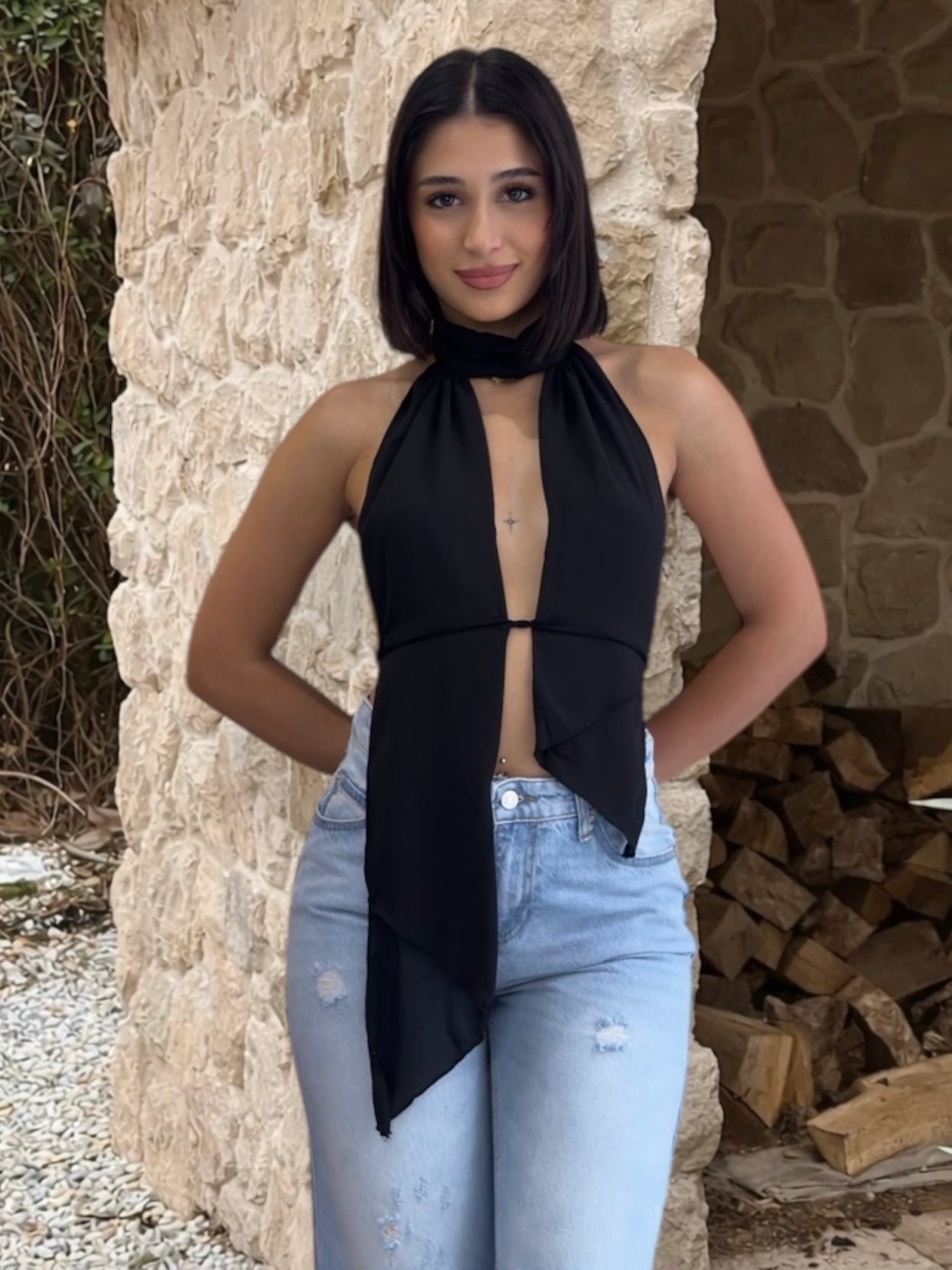 Black halter top with open back worn by a person in nature