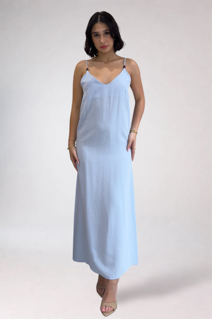 Woman wearing a light blue slip dress on a white background