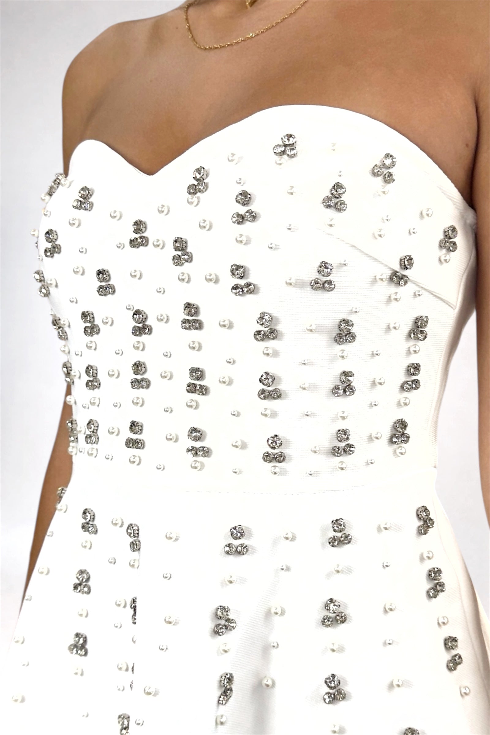 White strapless dress with silver embellishments on a white background