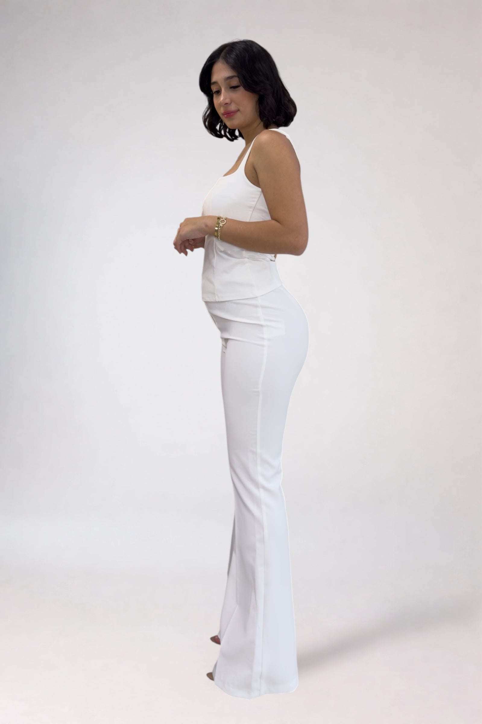 Woman wearing a white dress against a plain background