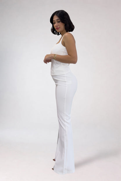 Woman wearing a white dress against a plain background