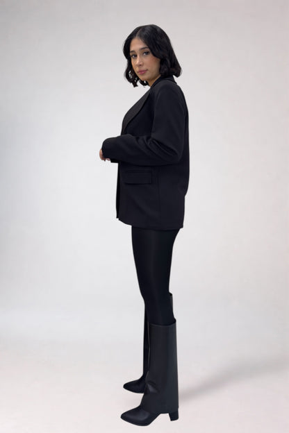 Person wearing a black suit with black boots on a white background