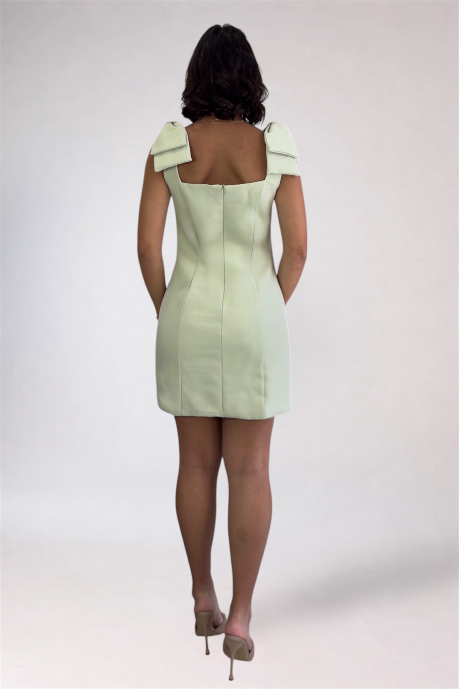 Light green dress with bow shoulders worn by a person on a white background