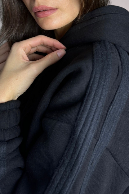 Person wearing a dark blue knitted sweater with a close-up of the fabric texture.