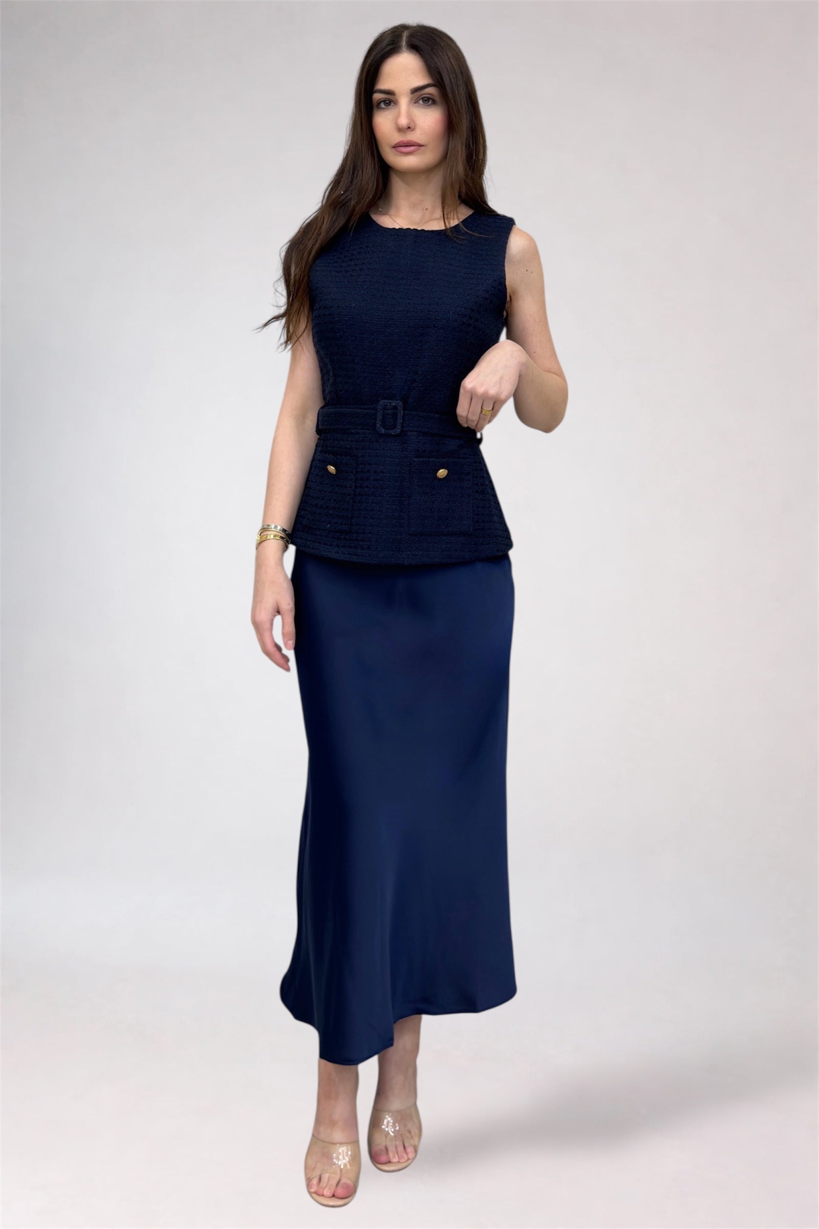 Woman wearing a navy blue sleeveless top and skirt set on a white background