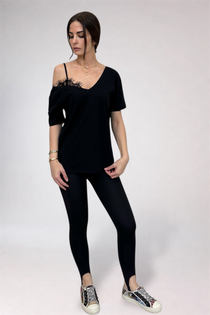 Woman wearing a black off-shoulder top and leggings on a white background