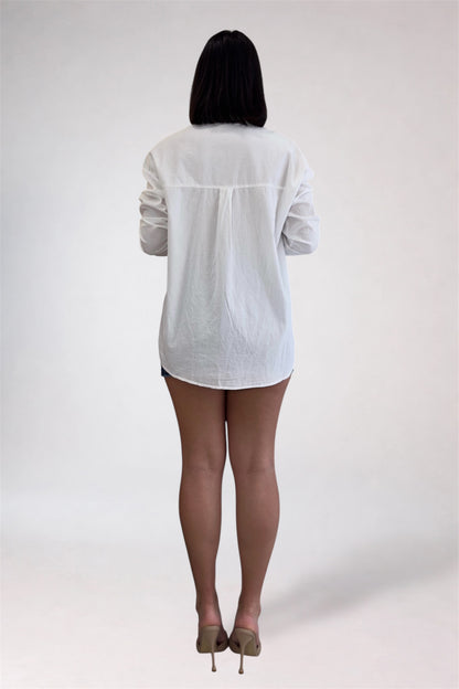 Person wearing a white shirt and black tights on a plain background