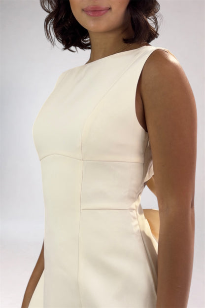 Woman wearing a light-colored dress against a plain background