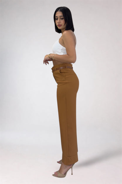 Woman wearing a white top and brown high-waisted pants on a white background