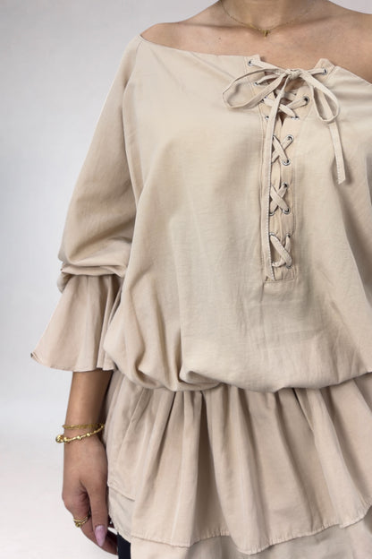 Beige off-shoulder top with lace-up detail on a white background