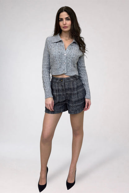 Woman wearing a patterned shirt and shorts on a white background