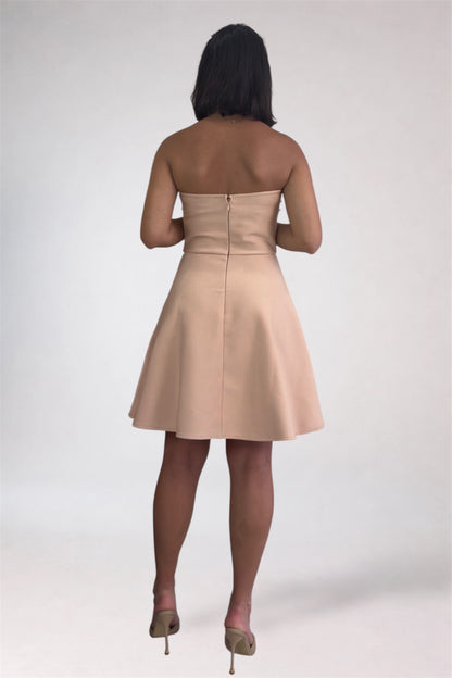 Woman wearing a beige strapless dress on a white background