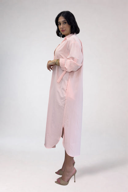Woman wearing a light pink dress against a white background