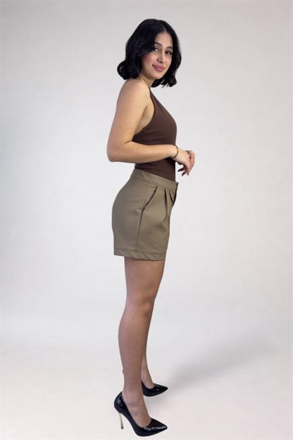 Woman wearing a brown top and beige shorts on a white background